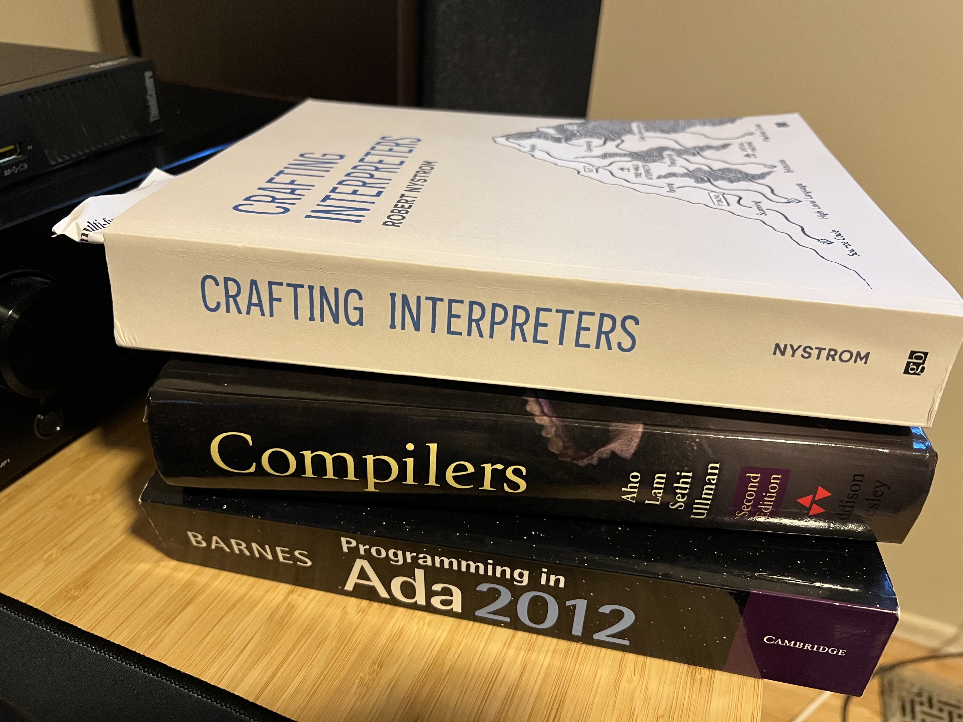 Book pile:

Crafting Interpreters by Robert Nystrom
Compilers (Dragon book) by Aho, Lam, Sethi and Ullman
Programming in Ada 2012 by John Barnes